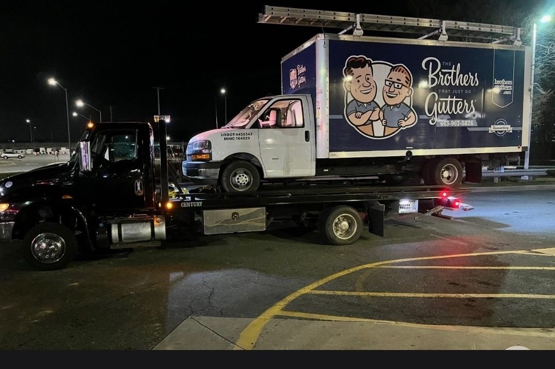 Box truck loaded on a Century flatbed at night in Baltimore